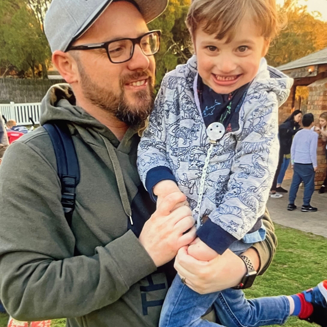 David holding his son Marcus in his arms who is smiling