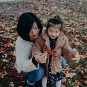 Michelle and young daughter Rosalie playing in the autumn leaves